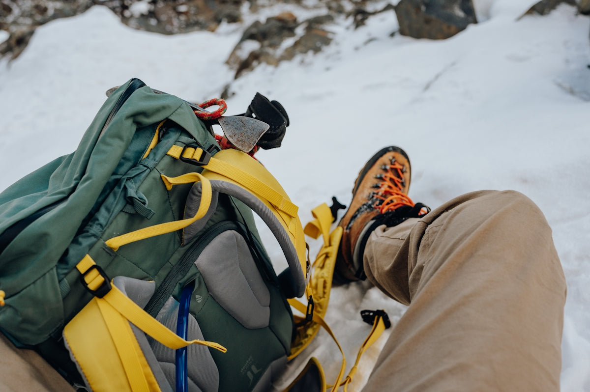Hiking gear rests in the snow.