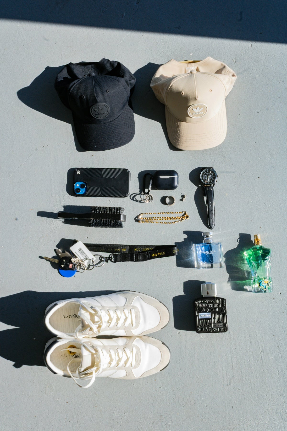 Collection of men's accessories including hats, phone, and cologne.