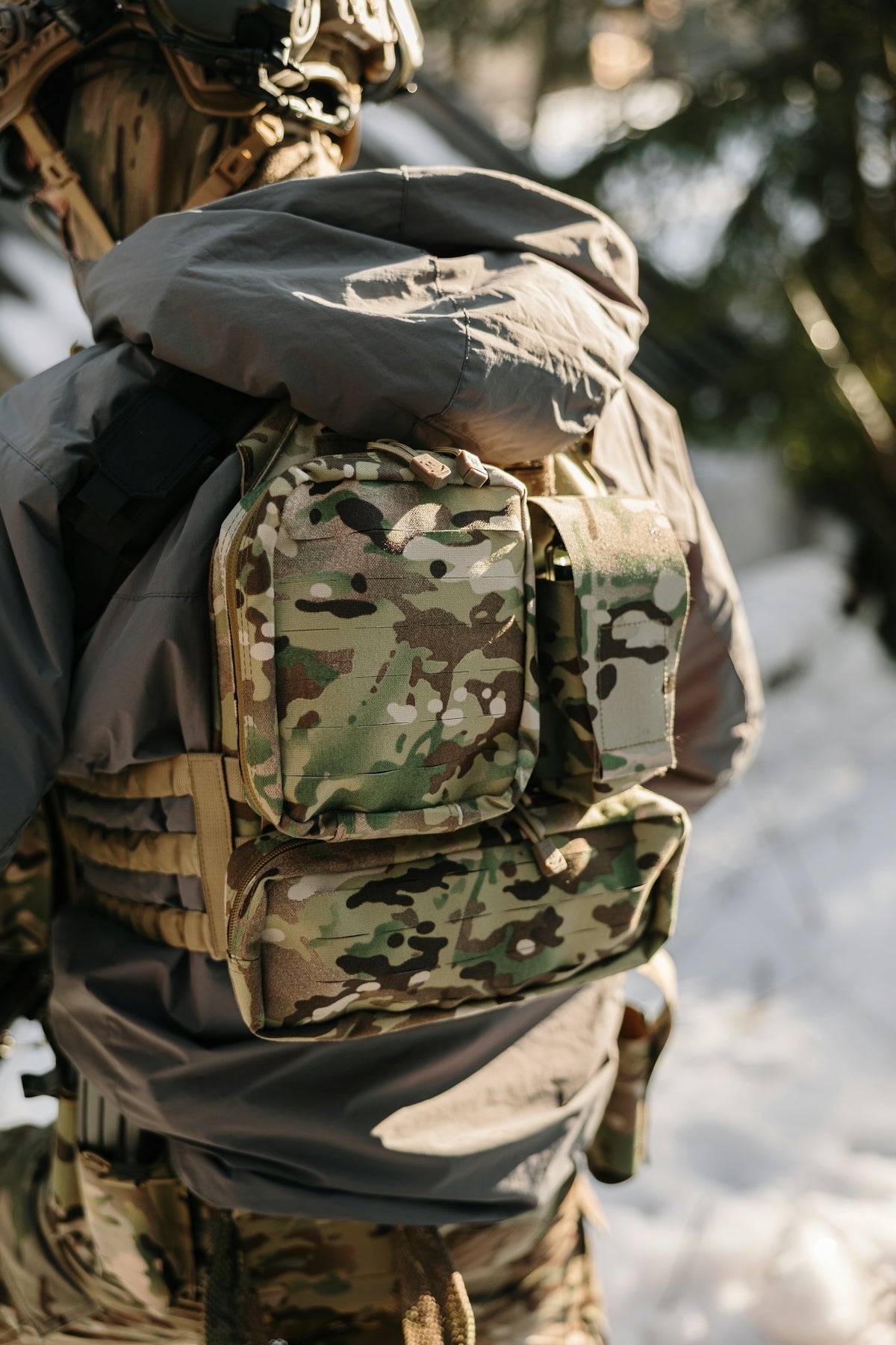 Soldier wearing tactical gear in a snowy forest