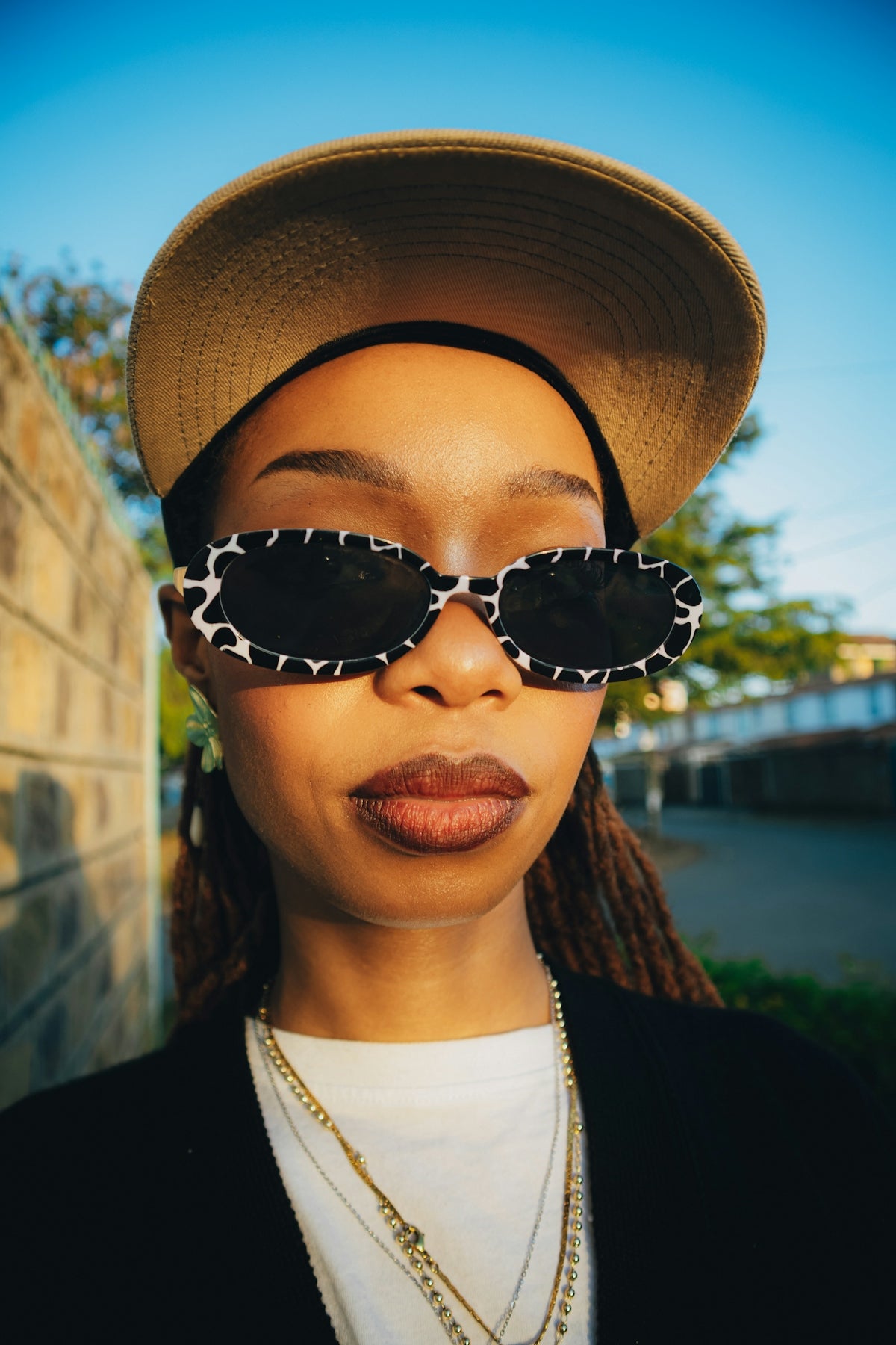 Woman wearing sunglasses and a baseball cap outdoors