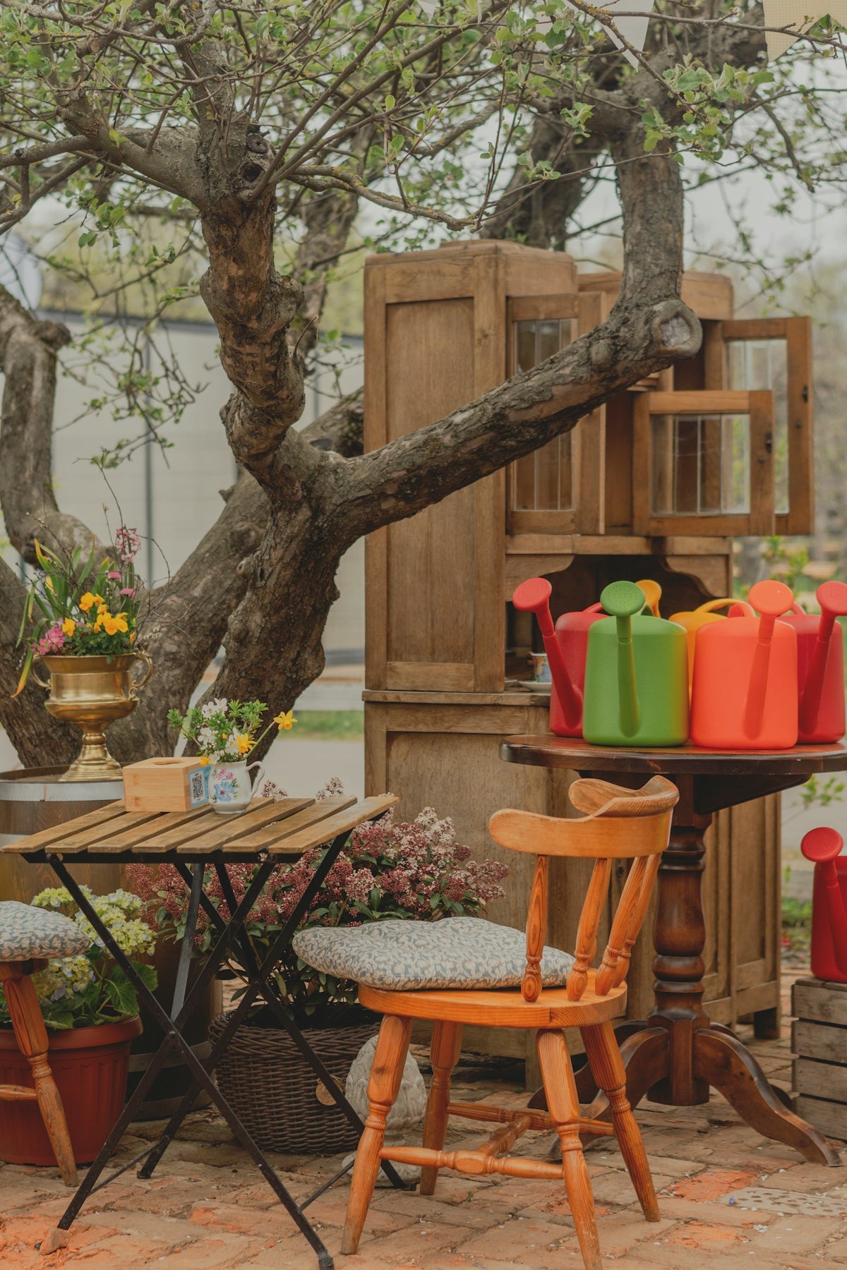 Outdoor seating area with watering cans and flowers